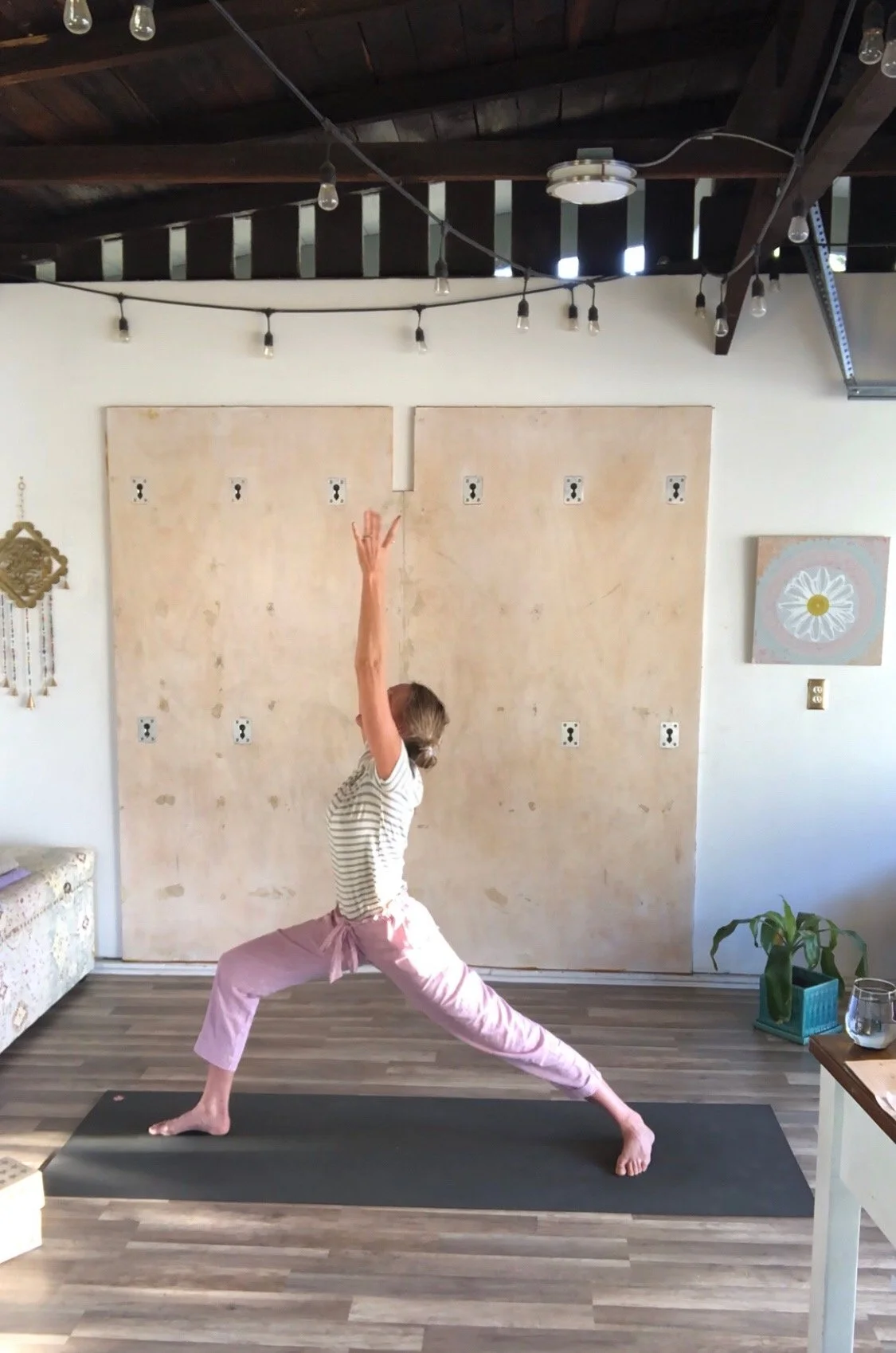 Carolina Goldberg in Warrior I inside her Pasadena Yoga Shala